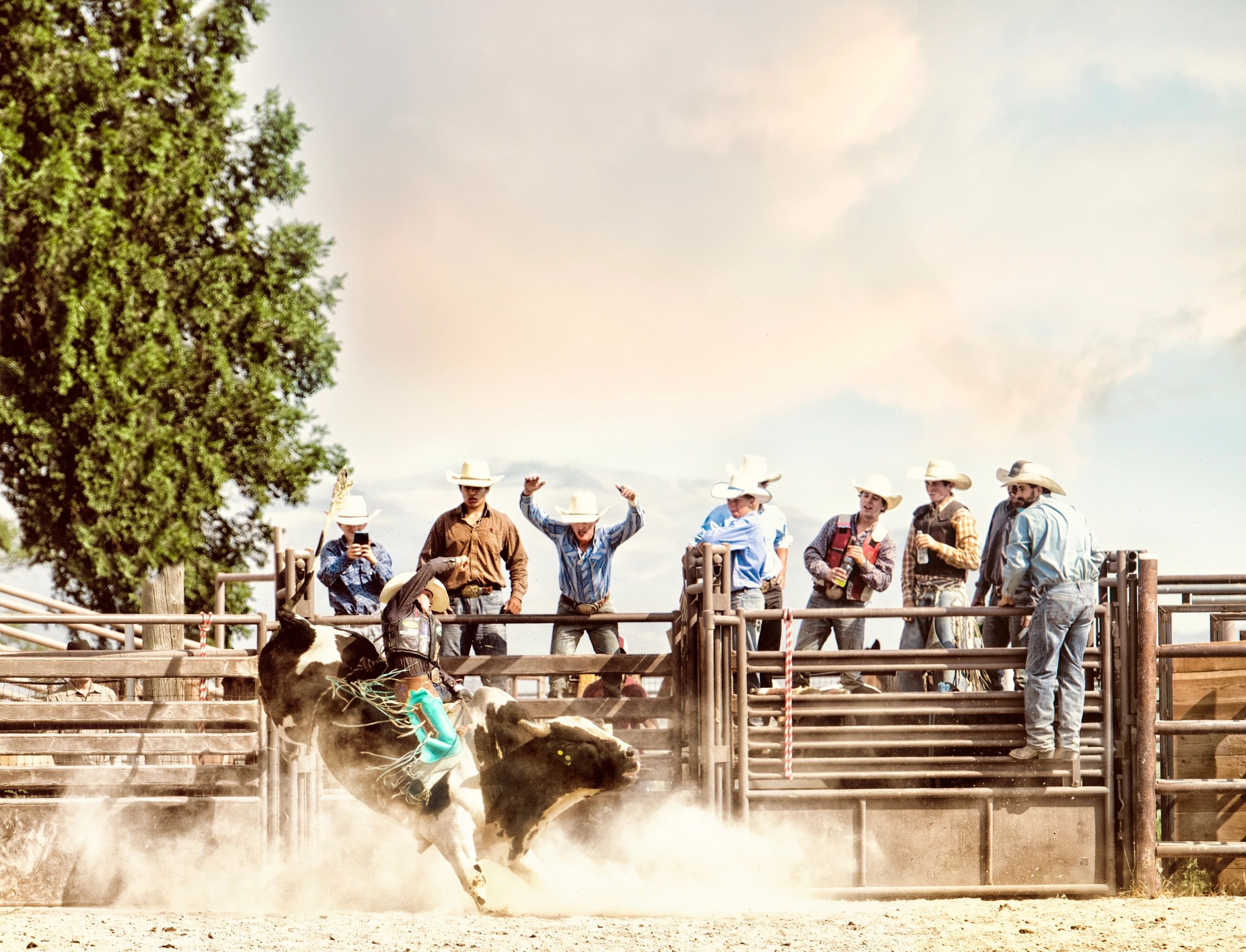 Bull rider in arena with crew in the background